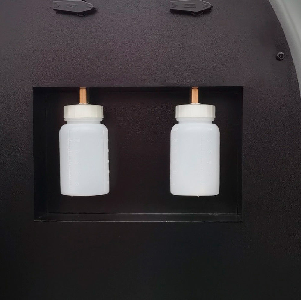 Dwa zbiorniki oleju stacji SM20 Drain Oil i Charge Oil w białych pojemnikach ze złączami mosiężnymi w komorze bocznej