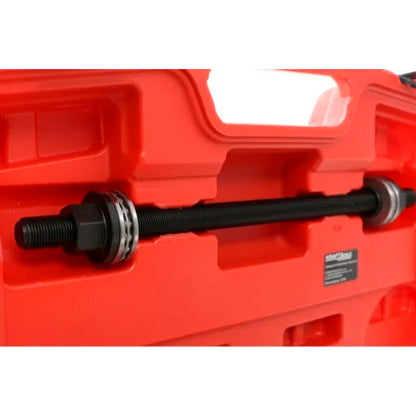 Śruba prowadząca z nakrętkami w czerwonej walizce zestawu do montażu i demontażu tulei, używana do prac serwisowych przy zawieszeniu pojazdów.