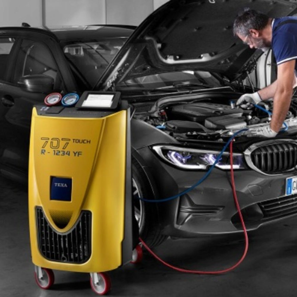 Stacja klimatyzacji TEXA KONFORT 707 TOUCH podłączona przewodami do układu klimatyzacji samochodu osobowego.