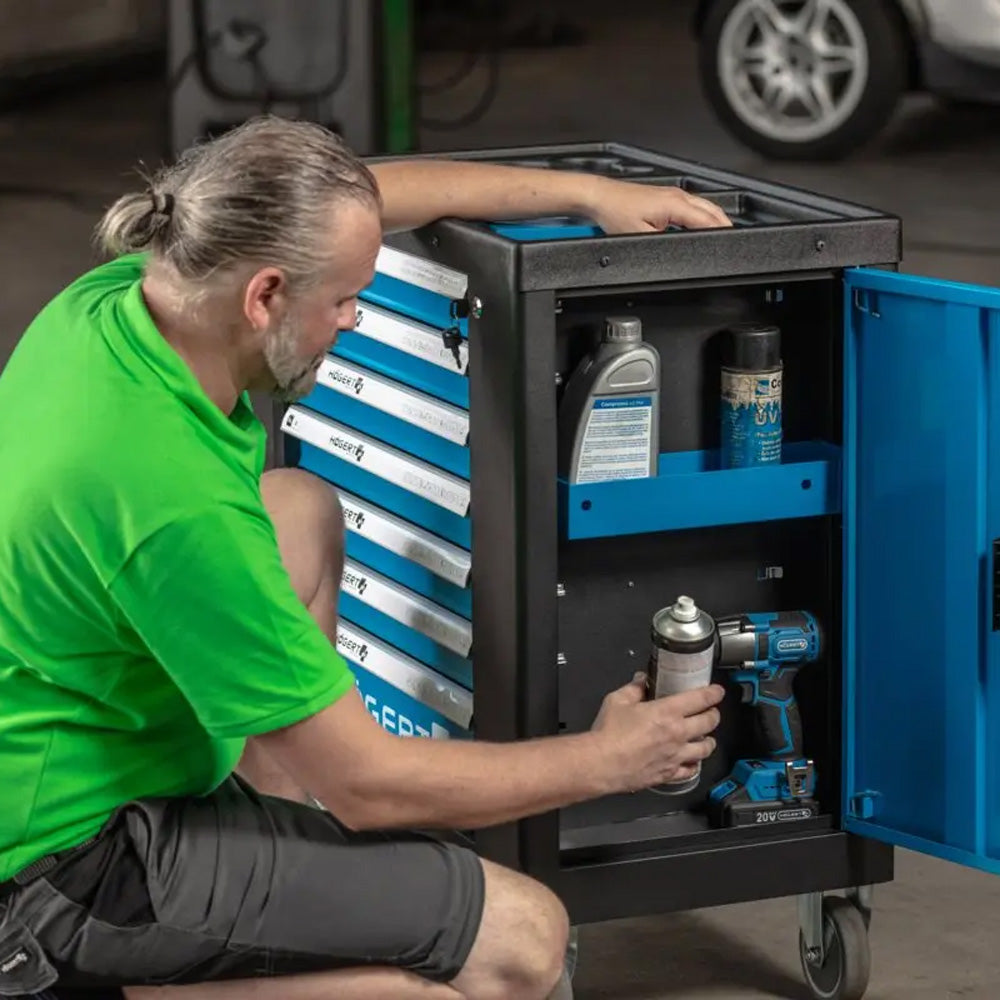 Wózek warsztatowy Högert HT7G050 — mechanik sięgający do otwartego schowka bocznego.